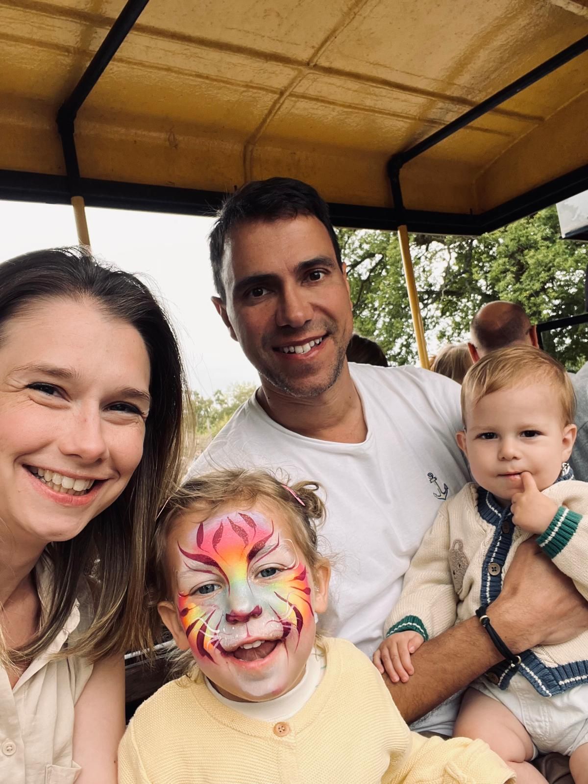Rob, Buffy, Clara and Sam together on a tractor ride, Clara in tiger face paint.